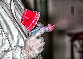 H tech styling spray gun spraying red paint